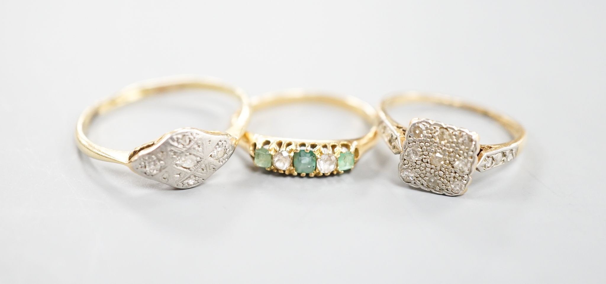 Two 18ct, plat. and diamond chip set dress rings and an 18ct, emerald and diamond set five stone ring, sizes P,I and H/I, gross weight 6 grams.